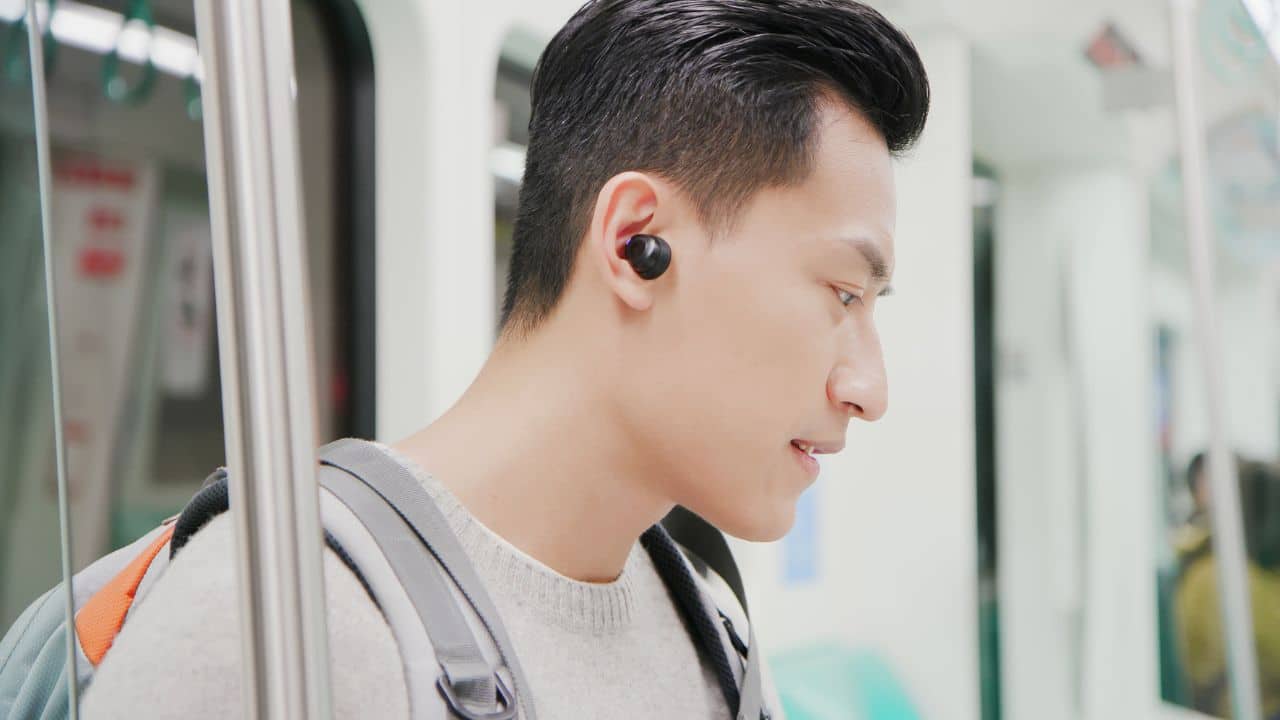 wearing-earbuds-on-train
